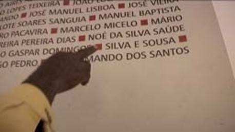 Um dos presos aponta o nome de um companheiro inscrito na exposição