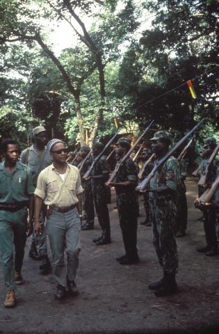 Amílcar Cabral passa revista a combatentes em formatura, acompanhado de Francisco Mendes (Tchico Té) e, em segundo plano, de Constantino Teixeira (Tchucho Akson). Fotografia de Bruna Polimeni