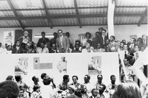 Proclamação da Independência de Cabo Verde, no Estádio da Várzea, na Cidade da Praia, 5 de julho de 1975. Na tribuna: José Carlos Schwartz, José Araújo, Ana Maria Cabral, Honório Chantre e outros; em baixo: Manuel Boal, Lilica Boal, Mário Pinto de Andrade, Júlio Semedo, Poupée Araújo e Bobo Queita